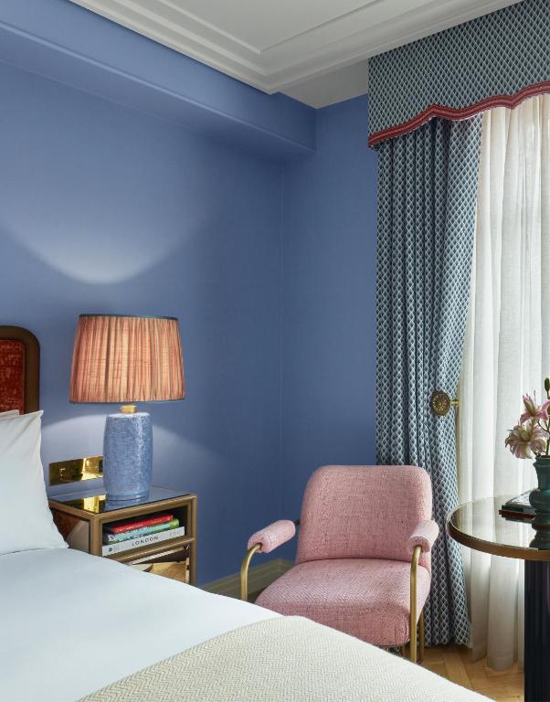 a bedroom with a bed and a chair and a table at Broadwick Soho in London