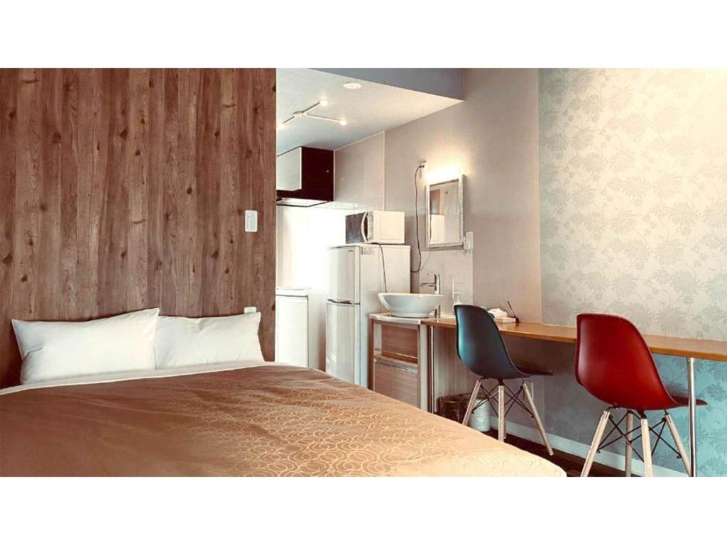 名護市にあるHYGGE biimata - Vacation STAY 06389vのベッドルーム1室(ベッド1台、椅子2脚付)、キッチンが備わります。