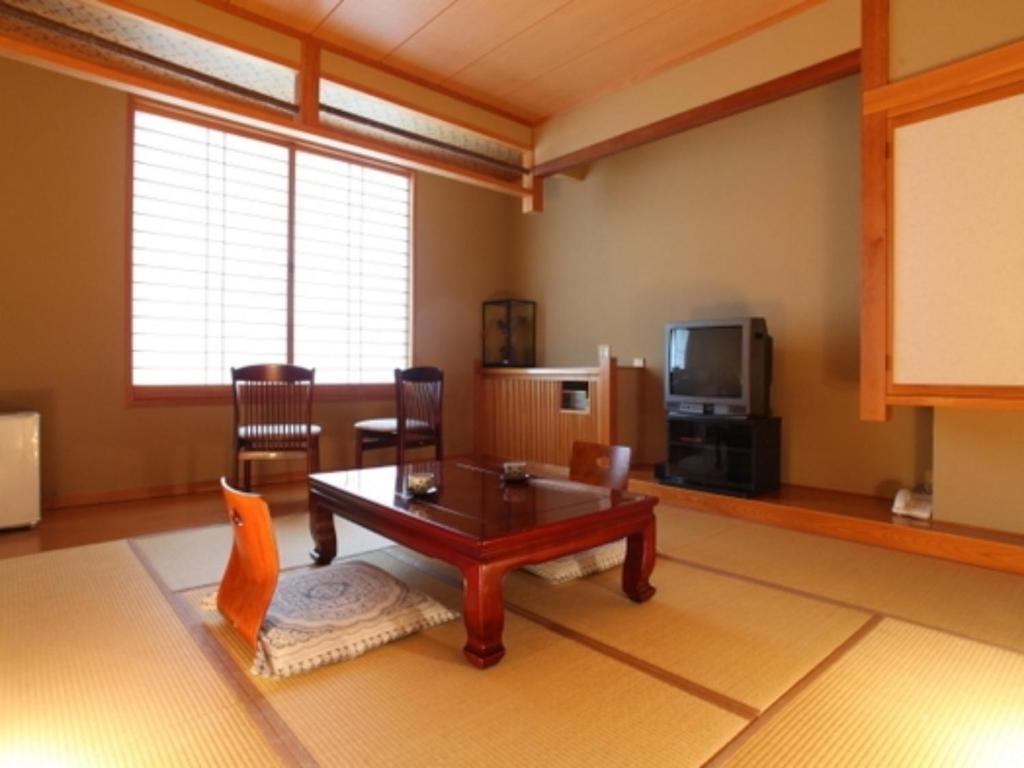 - un salon avec une table et une télévision dans l'établissement Nakanoyu Onsen Ryokan - Vacation STAY 06639v, à Matsumoto