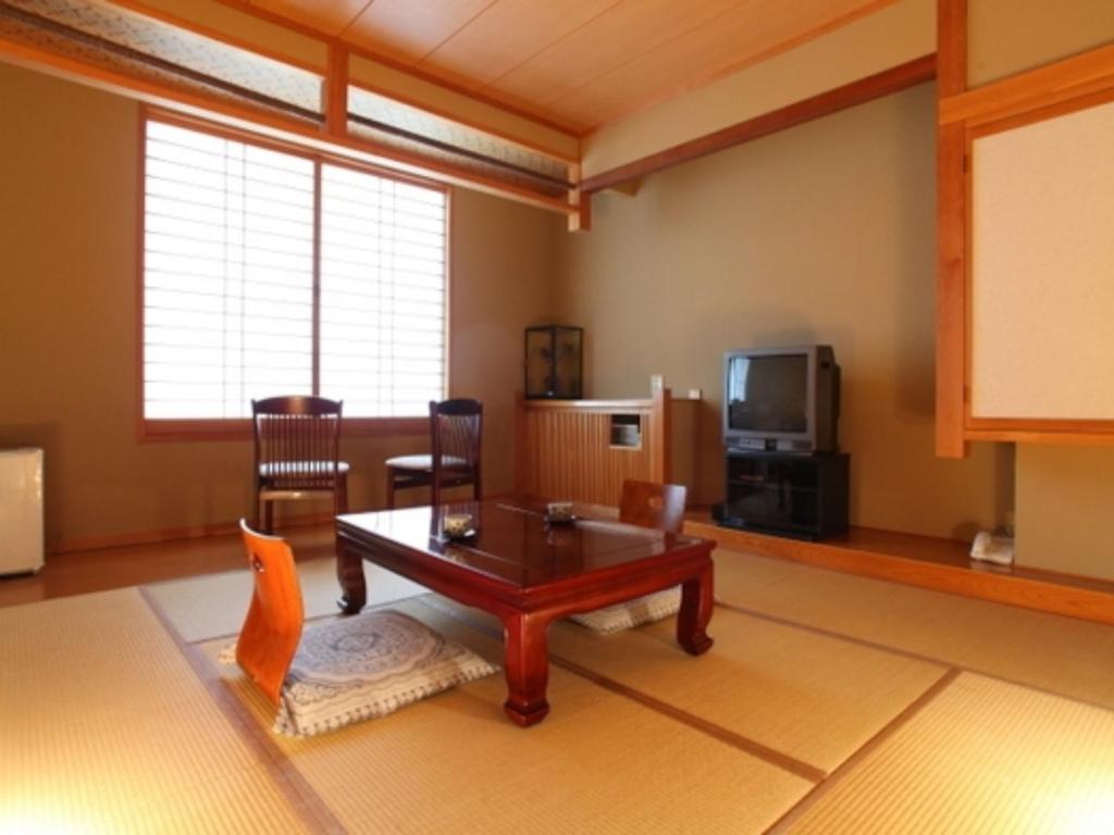 a living room with a table and a tv at Nakanoyu Onsen Ryokan - Vacation STAY 06639v in Matsumoto