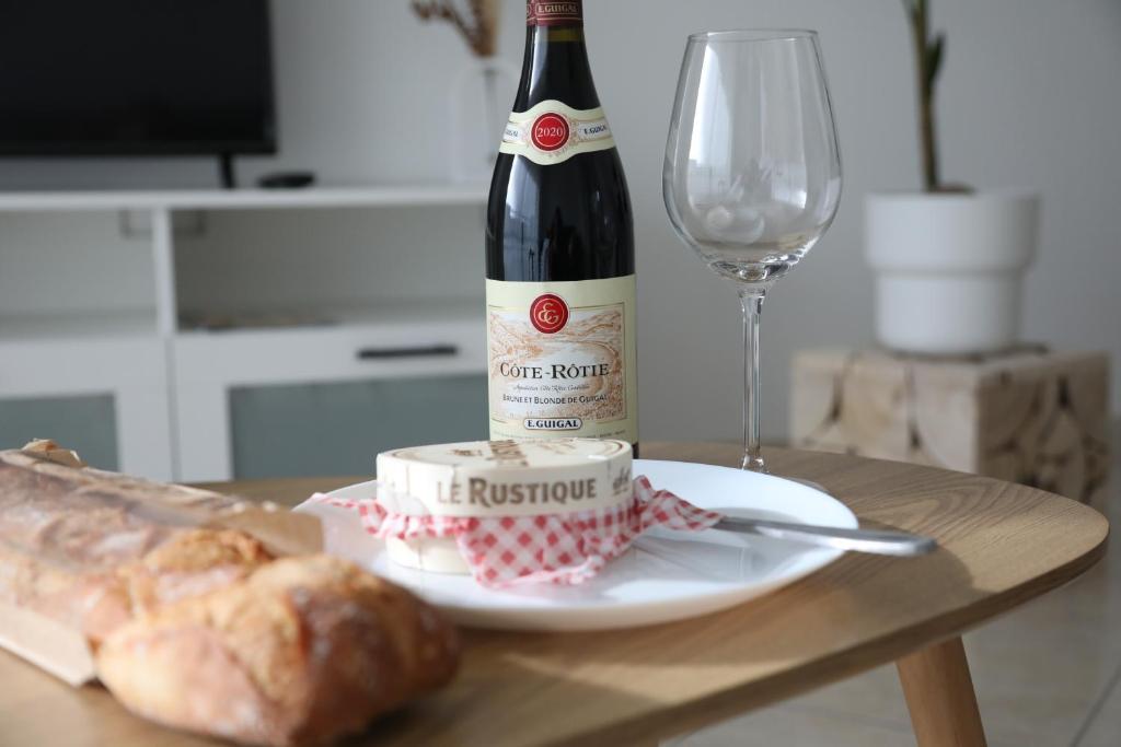 - une bouteille de vin, une assiette de pain et un verre dans l'établissement La Suite Est-Versaillais, à Saint-Cyr-lʼÉcole
