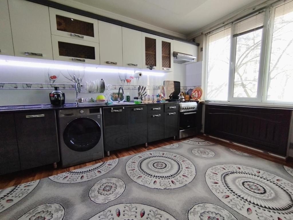 uma cozinha com máquina de lavar e secar roupa em Уютные апартаменты в центре em Tashkent