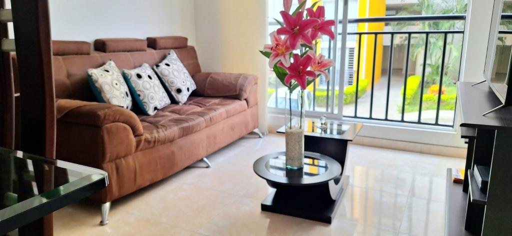 a living room with a couch and a table with a vase at CB2 Apto tranquilo con Aire Acondicionado in Neiva