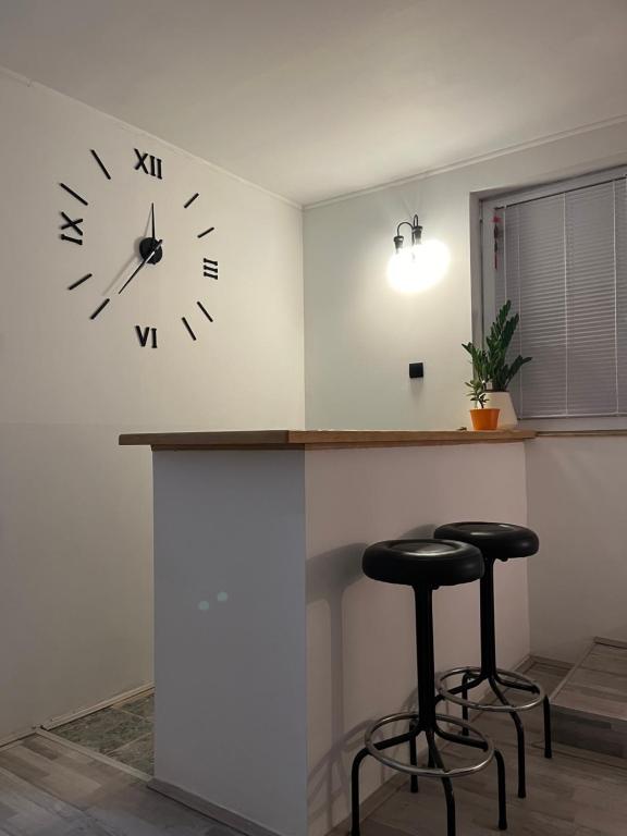 a counter with two stools and a clock on the wall at Skadarska in Pančevo