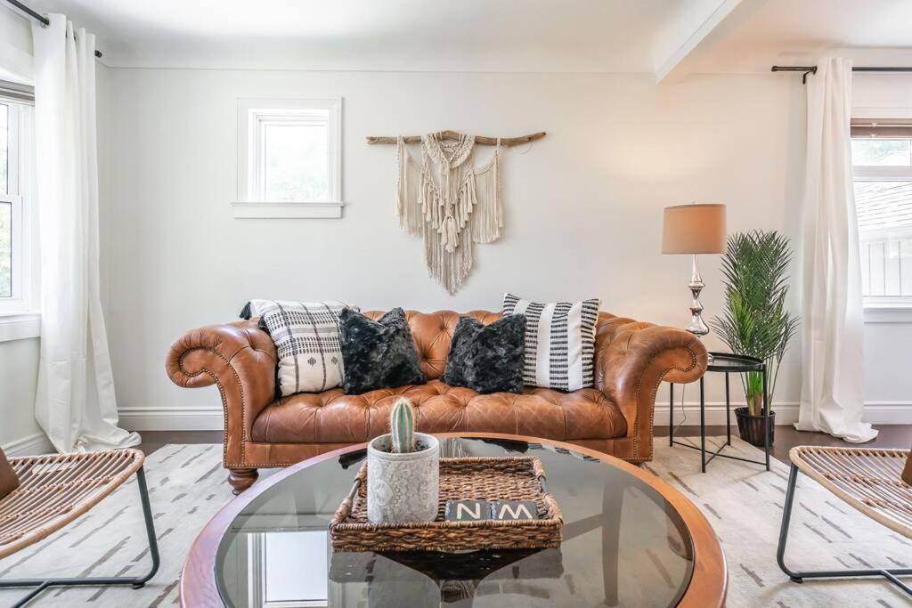 a living room with a brown couch and a glass table at Boho Inspired NOTL Wine Country Private Home for 2 in Niagara-on-the-Lake