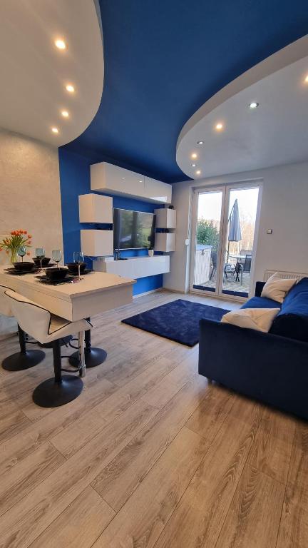 een blauwe kamer met een bureau en een bed bij BLUE APARTMENT in Polanica-Zdrój