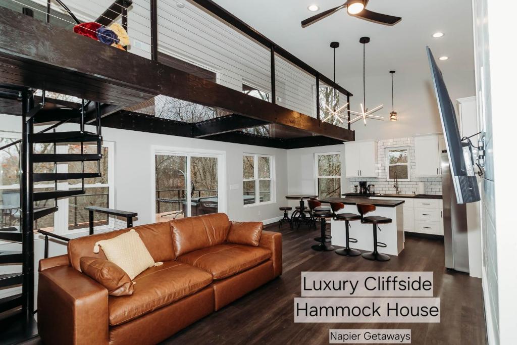 Il comprend un salon avec un canapé brun et une cuisine. dans l'établissement Luxury Cliffside Hammock House, à Wellington