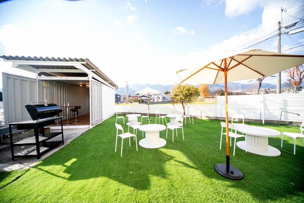 un patio con mesas y sillas blancas y un piano en Komono Garden Resort - Vacation STAY 06798v, 
