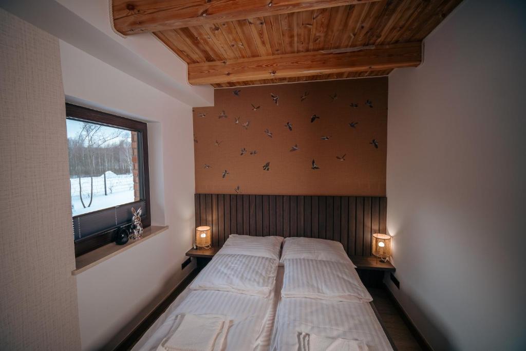 1 cama grande en un dormitorio con ventana en Marina KARO, en Brzeźno Szlacheckie