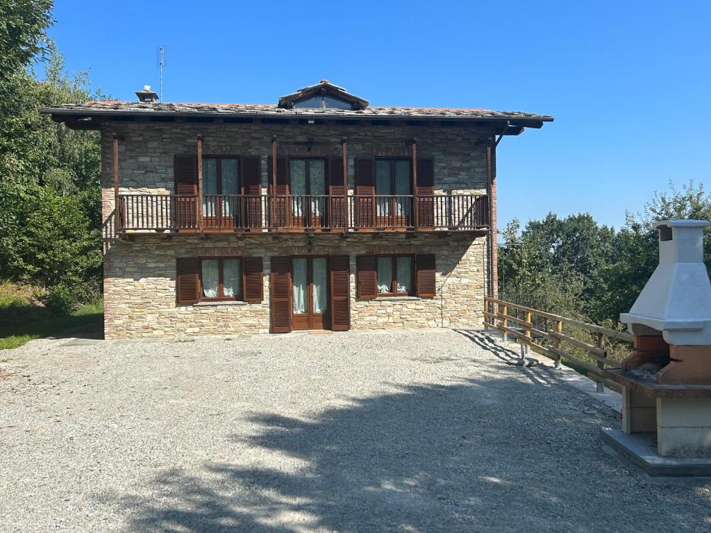 una casa in mattoni con balcone sopra di Casa Salada a Bagnolo Piemonte