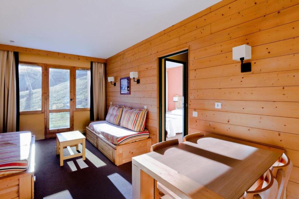 Cette chambre comprend un canapé et une chaise. dans l'établissement Résidence La Marelle et Le Rami - maeva Home - 2 Pièces 5 Personnes Sélection MAE-6534, à La Plagne Tarentaise
