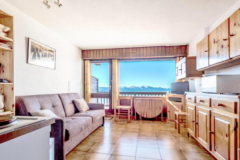 un salon avec un canapé et une cuisine dans l'établissement Studio 4 pers coeur de station - maeva Home - Studio 4 Personnes Confort MAE-7426, à Font-Romeu-Odeillo-Via