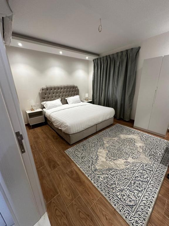 a bedroom with a bed and a rug at Roma house in Al Madinah