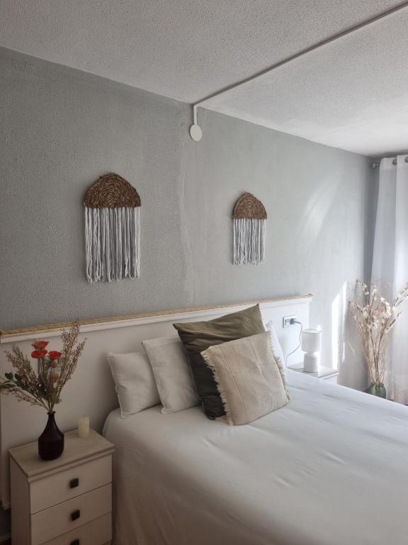a bedroom with a white bed and two windows at La Paserina in Arenas de Cabrales