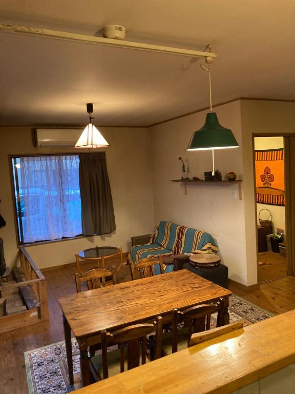ein Wohnzimmer mit einem Holztisch und Stühlen in der Unterkunft Minshuku Miyoshi - Vacation STAY 14454v in Echizen