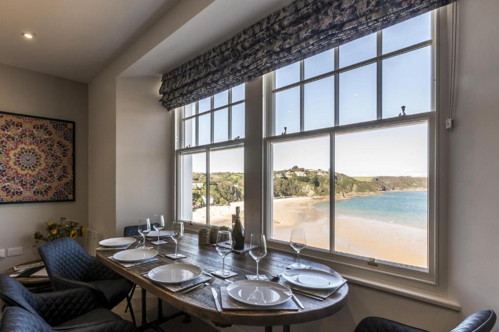 uma sala de jantar com uma mesa e uma grande janela em Lady Tenby - 2 Bedroom Apartment - Tenby (Windsor House) em Tenby