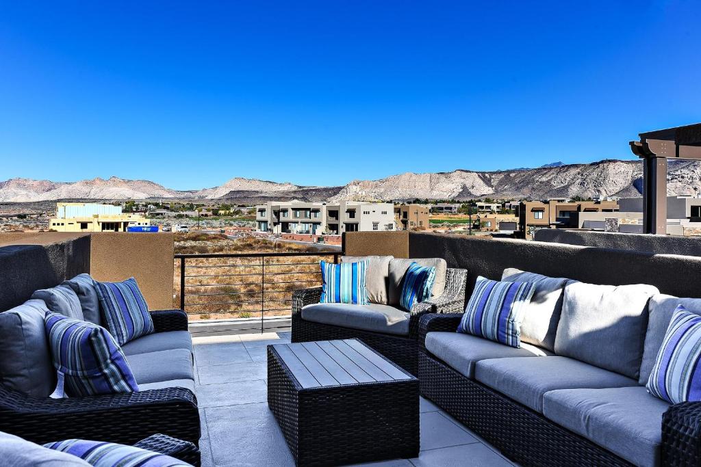 a patio with couches and a view of the mountains at Desert Dream in St. George