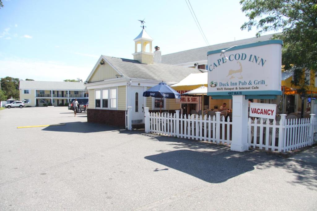 a store with a white fence next to a building at Cape Cod Inn in Hyannis