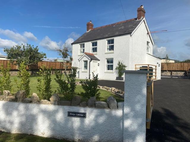 a white house with a sign in front of it at Elidyr Cottage - 3 Bedroom Cottage - Amroth in Amroth