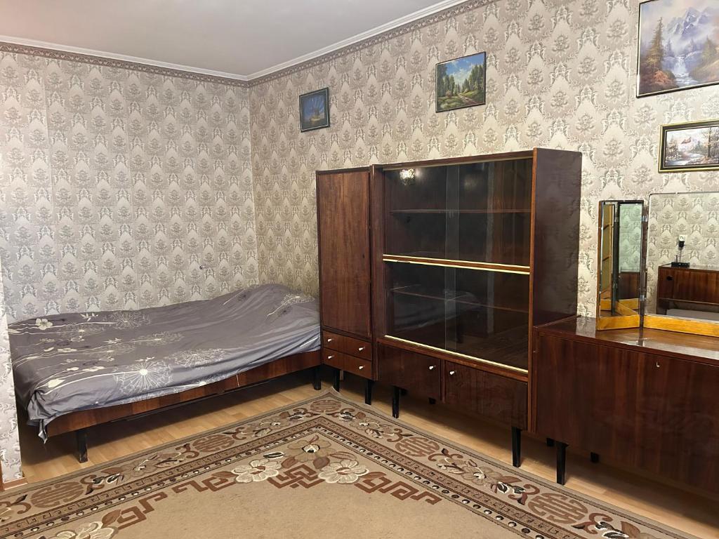 a bedroom with a bed and a wooden cabinet at Недорога квартира на Харківській, 32 in Sumy