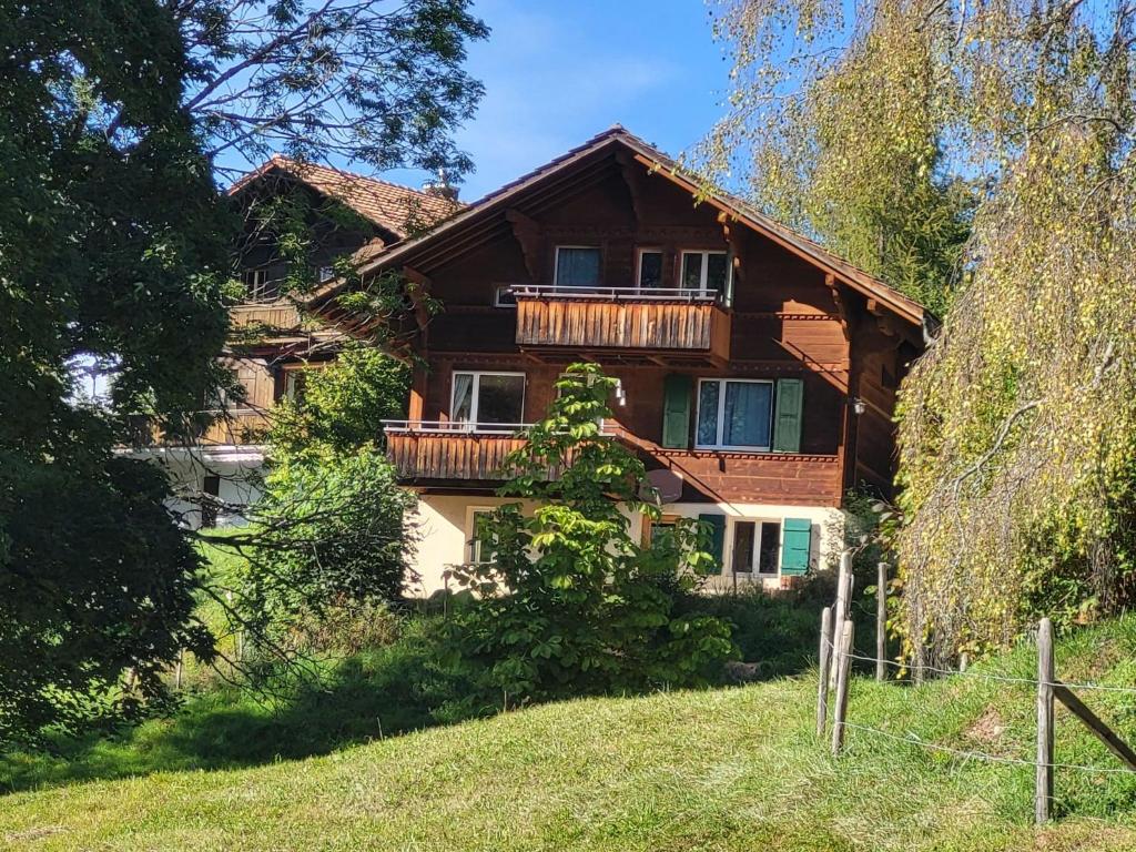 ein Holzhaus mit Balkon darüber in der Unterkunft Apartment Wildbach in Lenk im Simmental