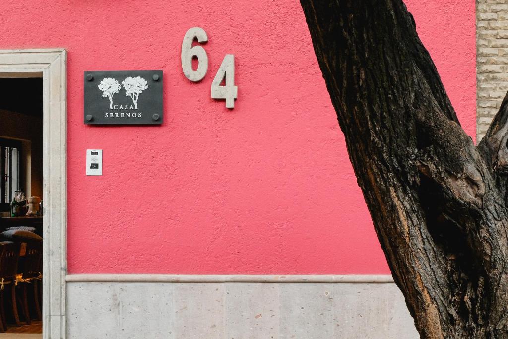 Una pared rosa con un cartel. en Casa Serenos, en Ciudad de México
