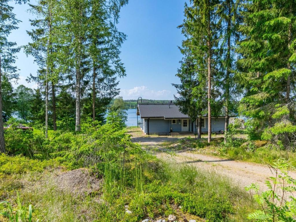 a house on the shore of a lake with trees at Holiday Home Eerola by Interhome in Joutsa