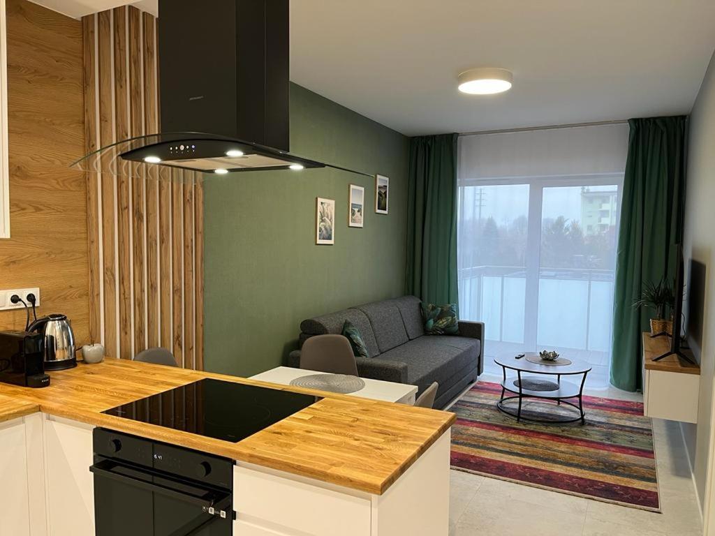 a kitchen and a living room with a couch at Apartament Zacisze 14 in Piaseczno