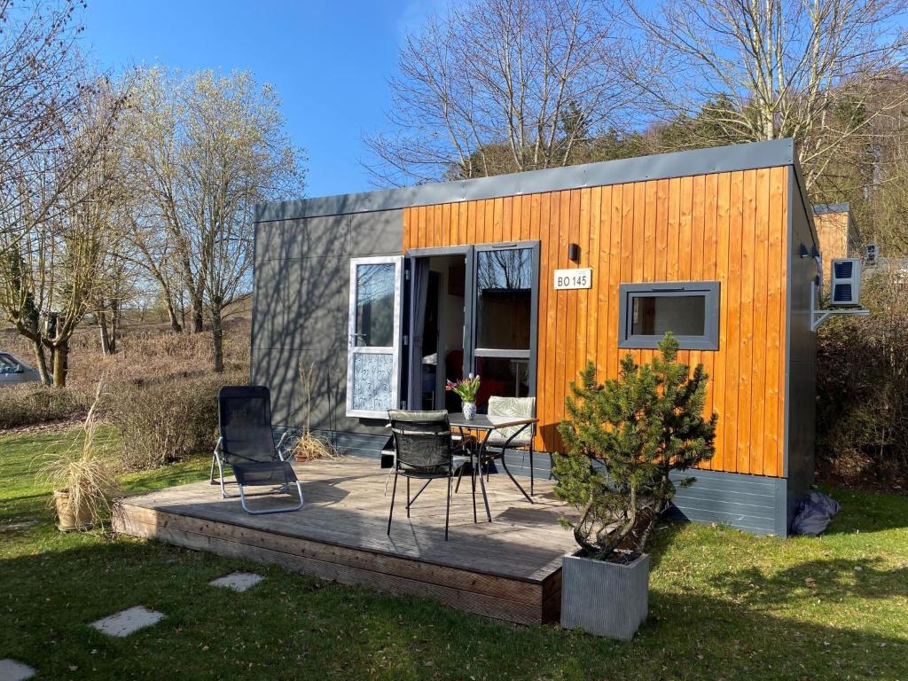 een tiny house op een terras met een tafel en stoelen bij Holiday Home Motte by Interhome in Wemding