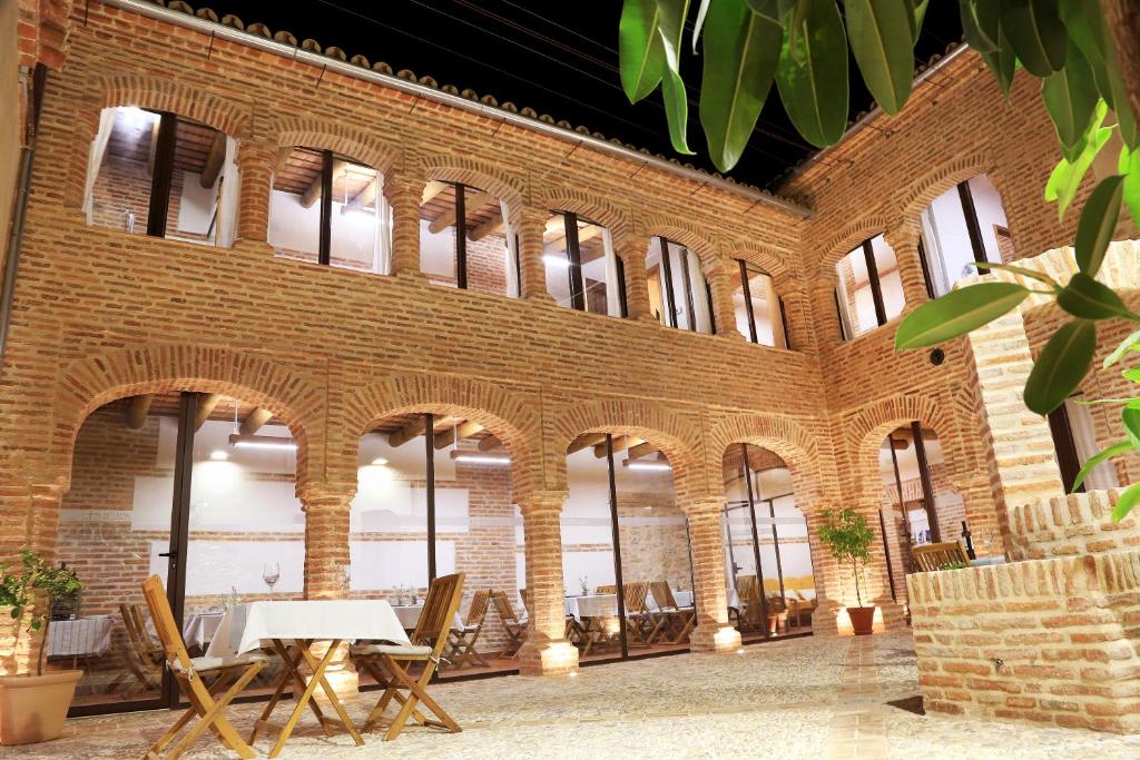 un gran edificio de ladrillo con mesa y sillas en casa rural Cieza de León, en Llerena