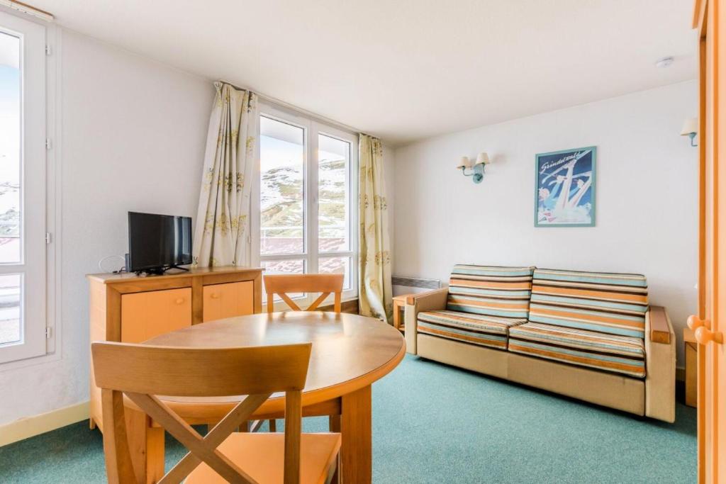 un salon avec une table et un canapé dans l'établissement Résidence Le Montana - maeva Home - Studio 2 Personnes Confort MAE-9706, à La Mongie