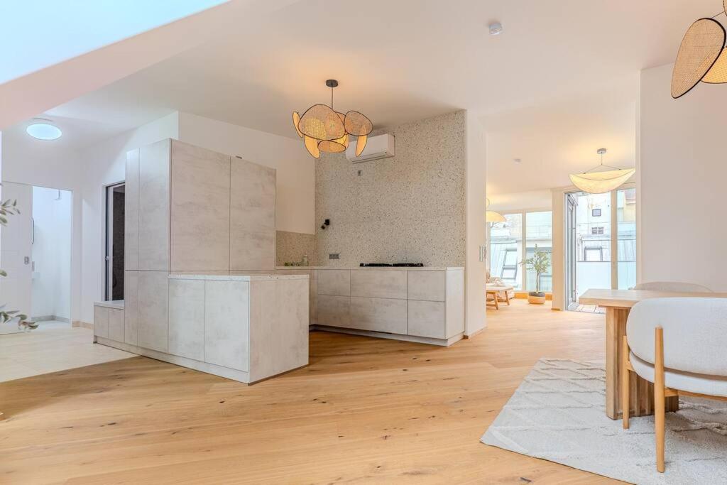 Hotel Neustift Deluxe, a large white kitchen with a table and chairs at Neustift Deluxe in Vienna