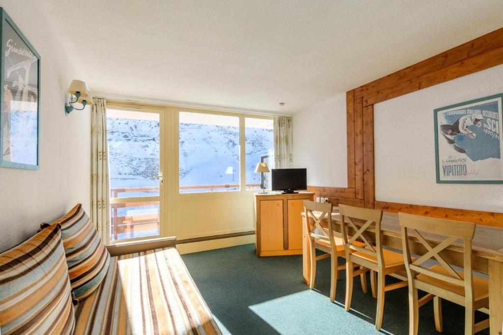 une pièce avec une table, des chaises et une fenêtre dans l'établissement Résidence Le Montana - maeva Home - 2 pièces 6 Personnes Sélection MAE-9713, à La Mongie