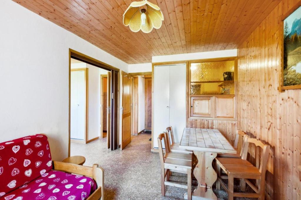 ein Wohnzimmer mit einem Tisch und einem roten Sofa in der Unterkunft Chalet le Séchet - Maeva Particuliers - 2 Pièces 4 personnes Confort 140615 in Bellentre