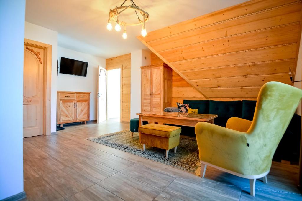 salon z drewnianym sufitem, stołem i krzesłami w obiekcie Sielski Zakątek w Zakopanem