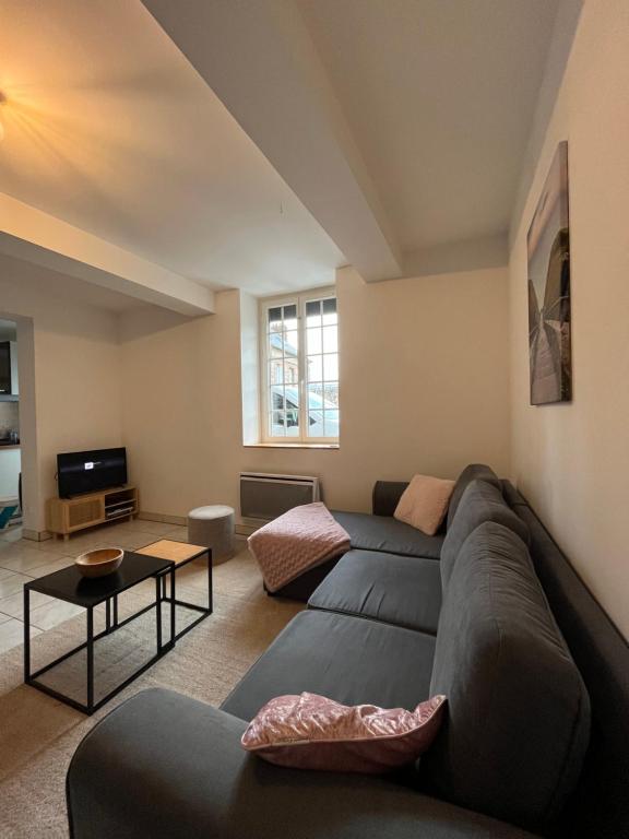 un salon avec un canapé et une télévision dans l'établissement Maison normande silex proche de la mer, à Sotteville-sur-Mer
