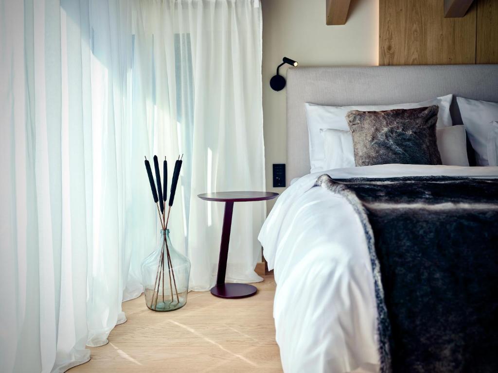 - une chambre avec un lit avec un vase et une table dans l'établissement Haus am Lift, à Zell am See