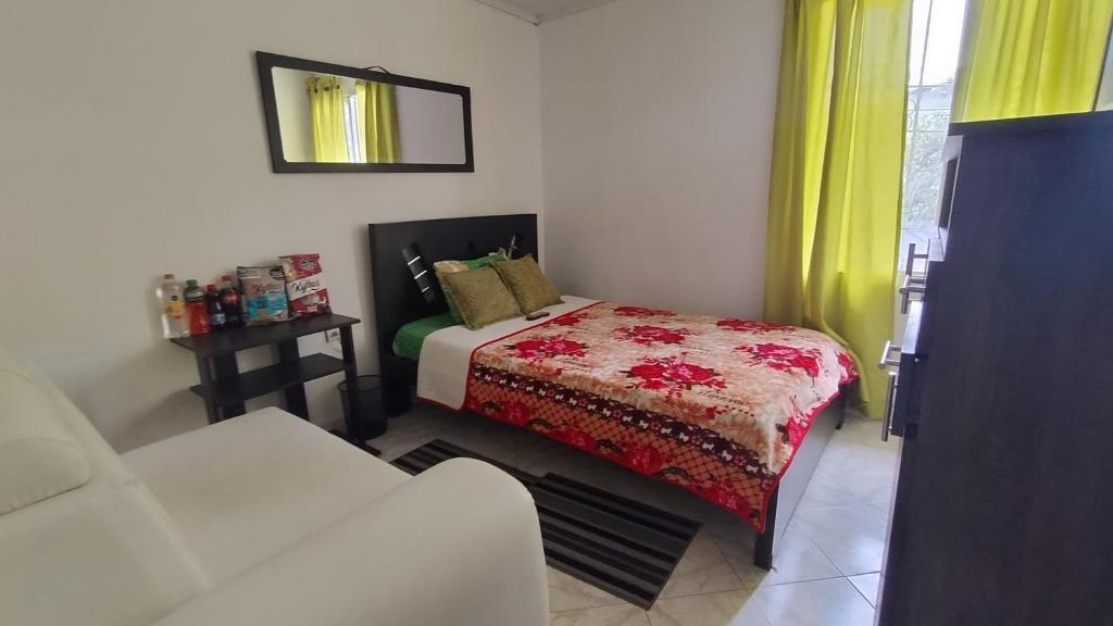 Habitación pequeña con cama y sofá en ELVIAJERO HOSTAL en Popayán
