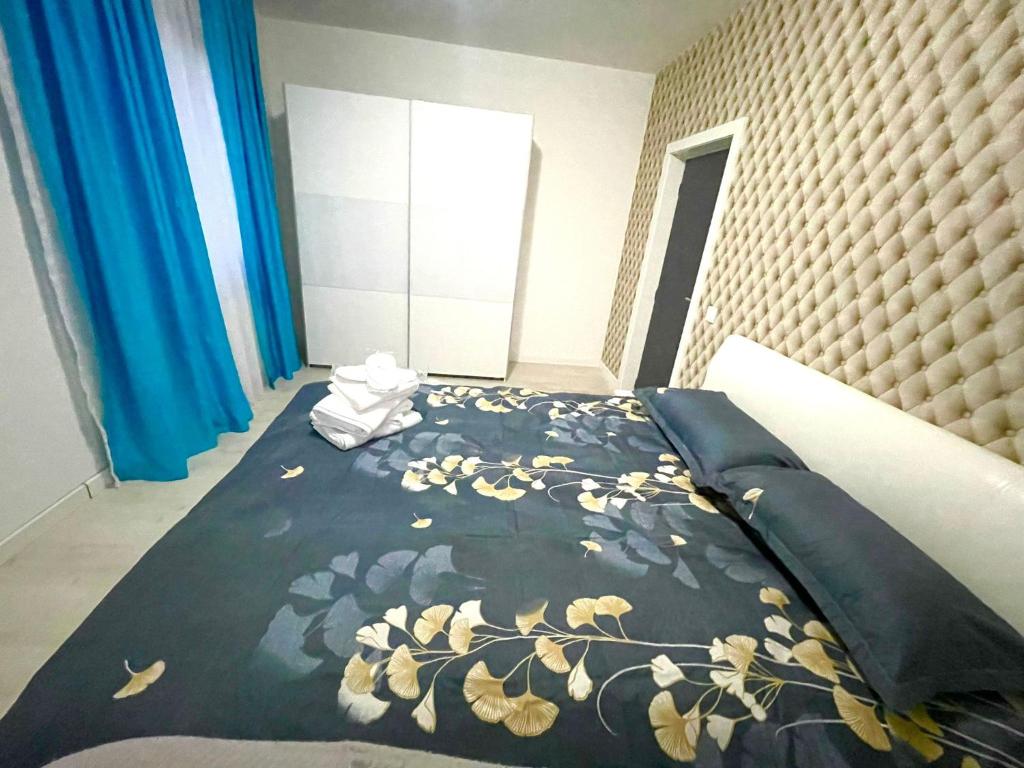 1 Schlafzimmer mit einem Bett mit Blumenbettdecke in der Unterkunft Residence 3 in Ploieşti