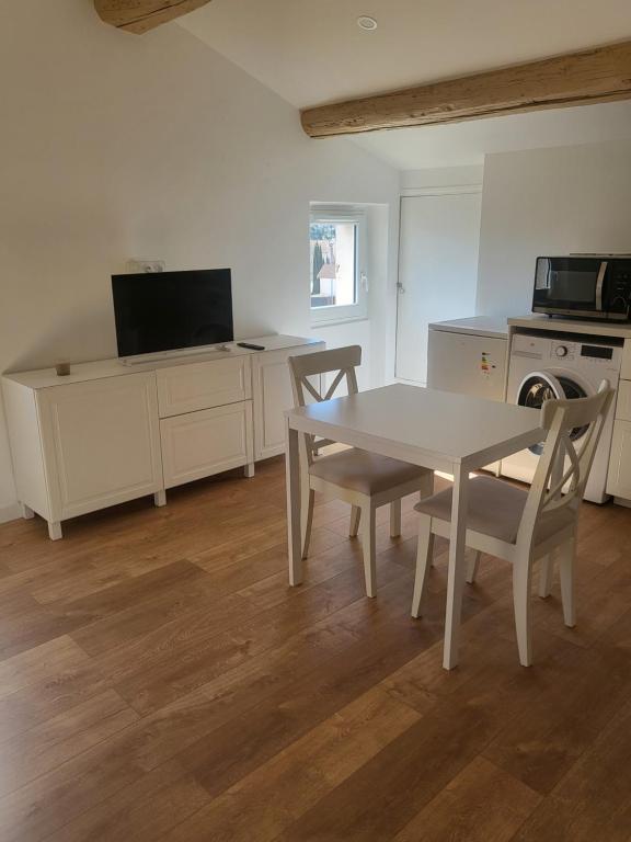 a white kitchen with a table and chairs and a microwave at Top studio + Parking + Wifi in Toulon