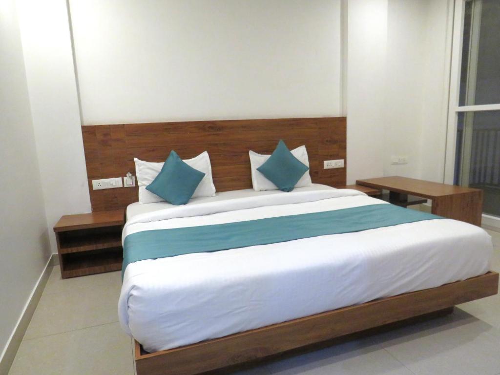 a bedroom with a large bed with blue pillows at The Namami Tapovan in Rishīkesh