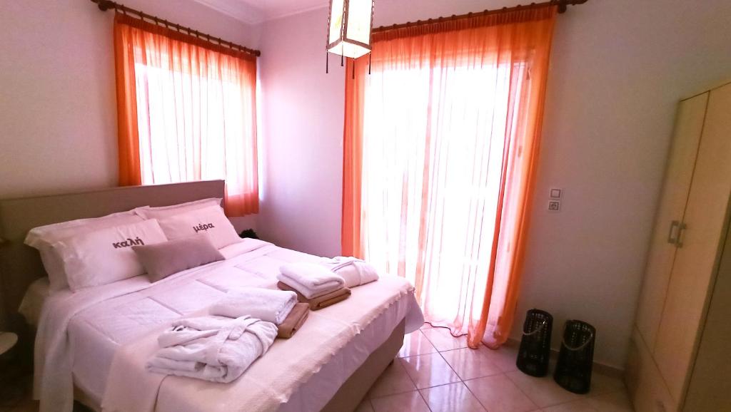 Un dormitorio con una cama blanca con toallas. en Paradise Beach House, en Flámbouras