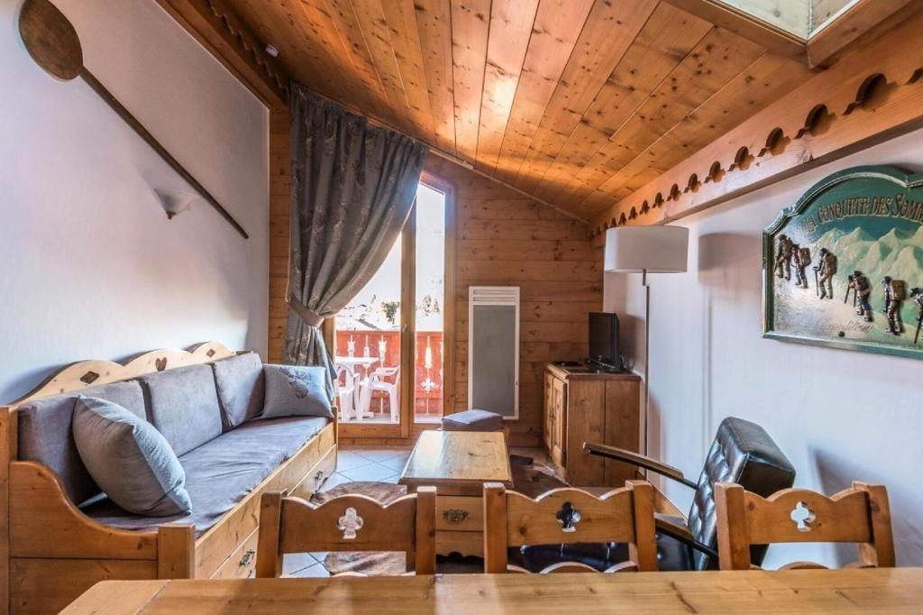 een woonkamer met een bank en een tafel bij Résidence Les Fermes du Soleil - maeva Home - Appartement 4 pièces 7 person 93 in Les Carroz d'Araches