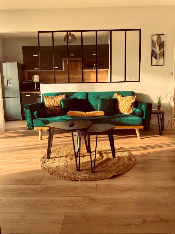 - un salon avec un canapé vert et une table basse dans l'établissement Spacieux appartement lumineux, à Brest