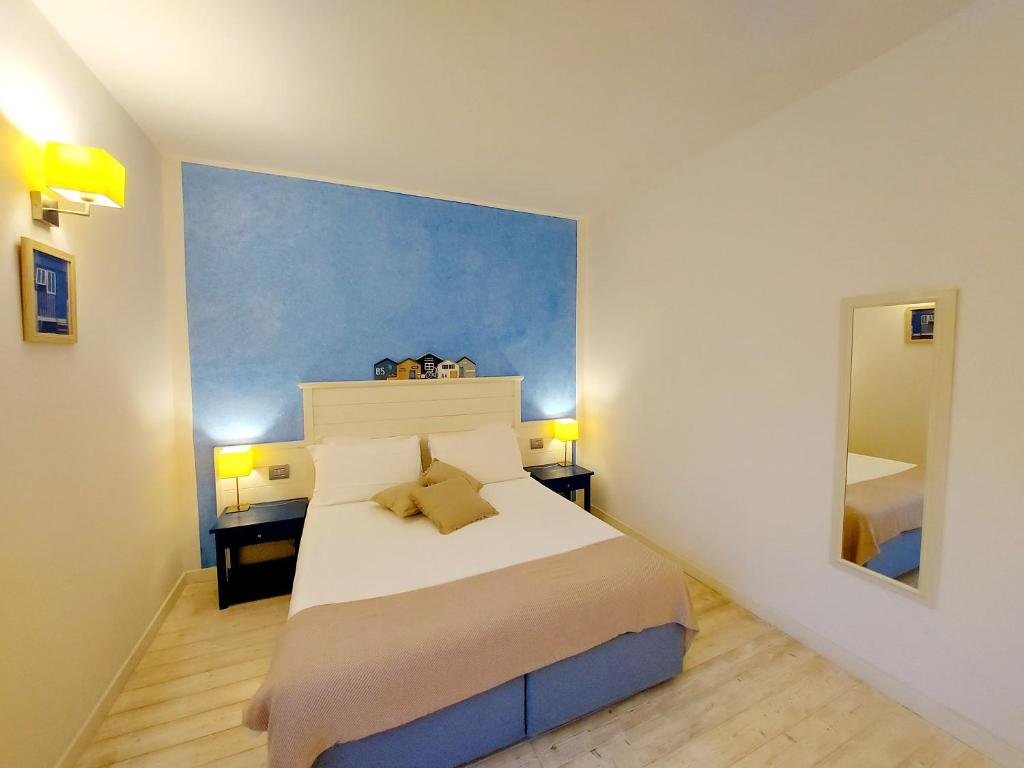 a bedroom with a bed and a painting on the wall at Hotel La Villa Del Mare in Cagliari