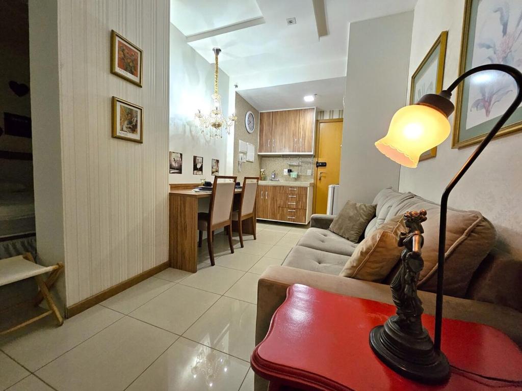 a living room with a couch and a table with a lamp at Lindo e decorado, Hotel Vista in Brasília