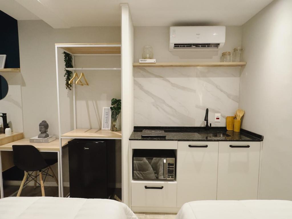a kitchen with white cabinets and a counter top at Apê Pátio Paulista in São Paulo