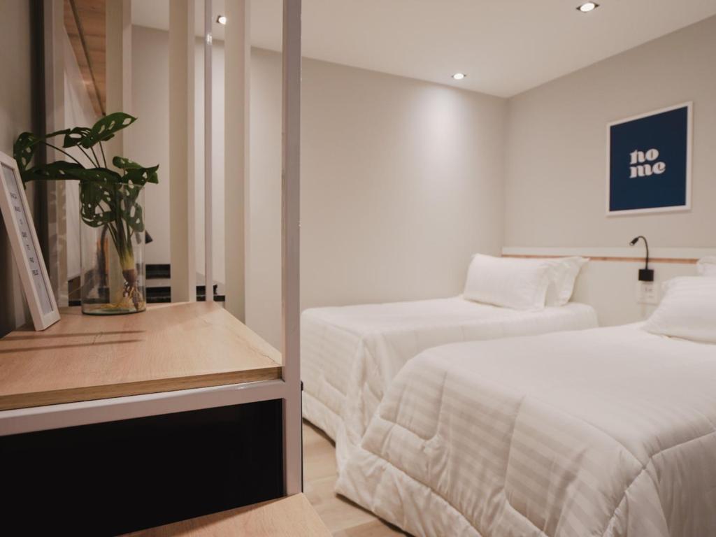a hotel room with two beds and a mirror at Apê Pátio Paulista in São Paulo