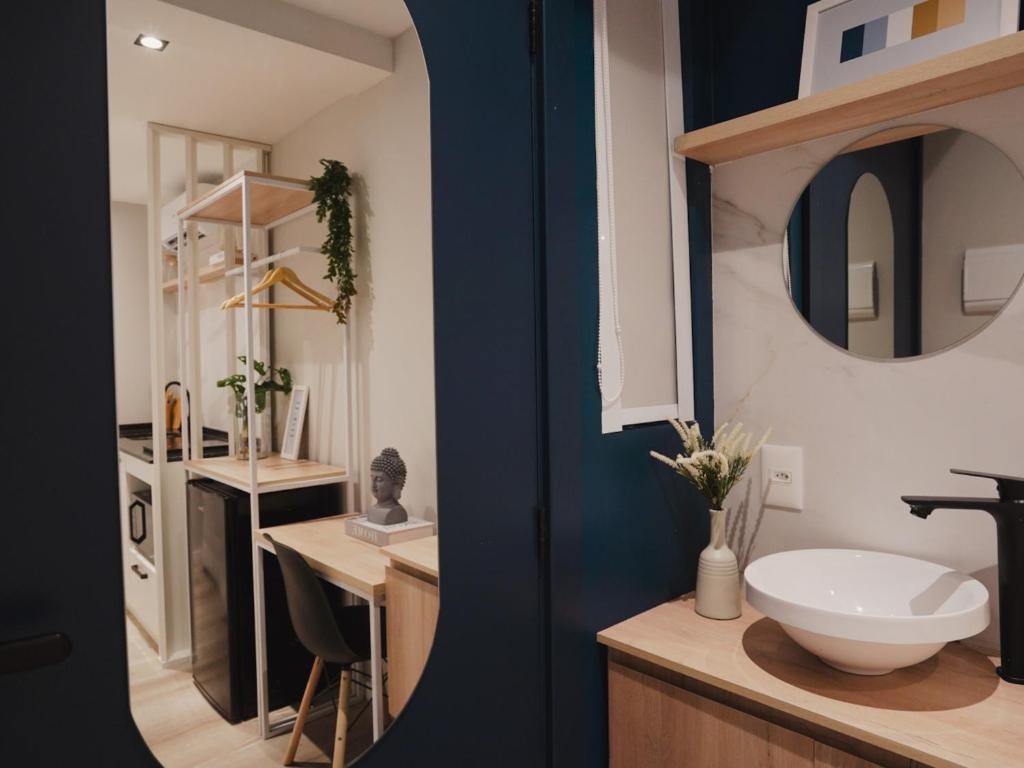 a bathroom with a sink and a counter with a mirror at Apê Pátio Paulista in São Paulo