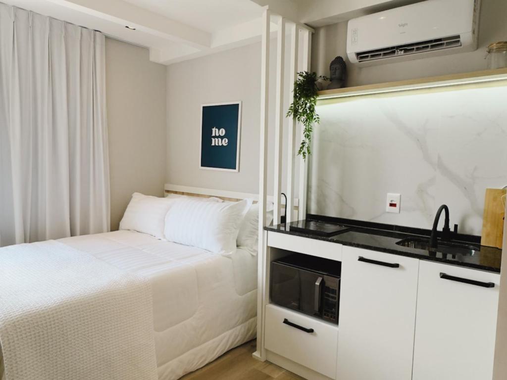 a small bedroom with a bed and a sink at Apê Pátio Paulista in São Paulo